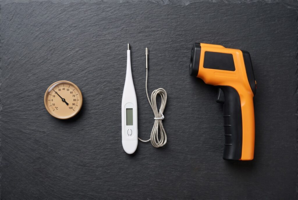 Three reptile thermometer types side by side: stick-on dial, digital probe, and infrared gun